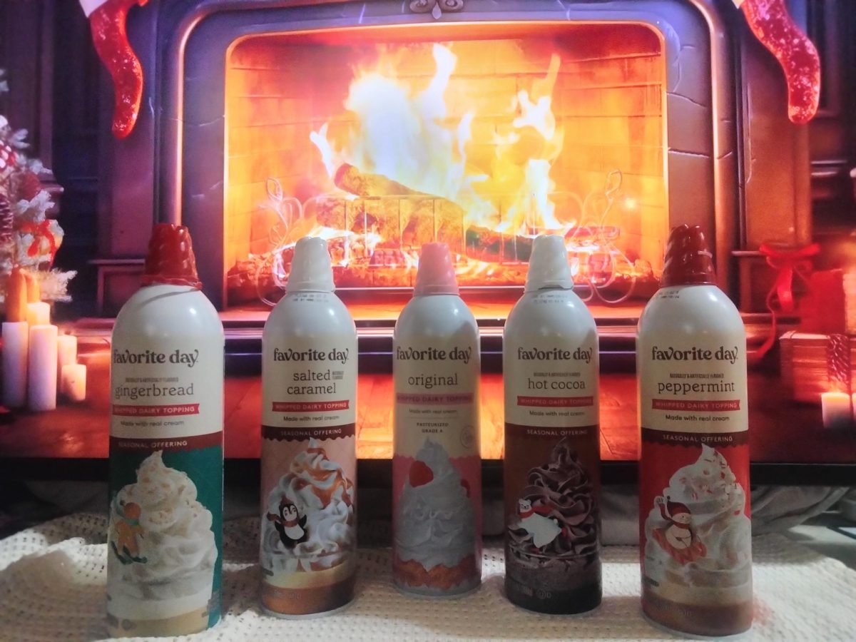 Several whipped cream cans of different flavors stand in a line in front of a fireplace.